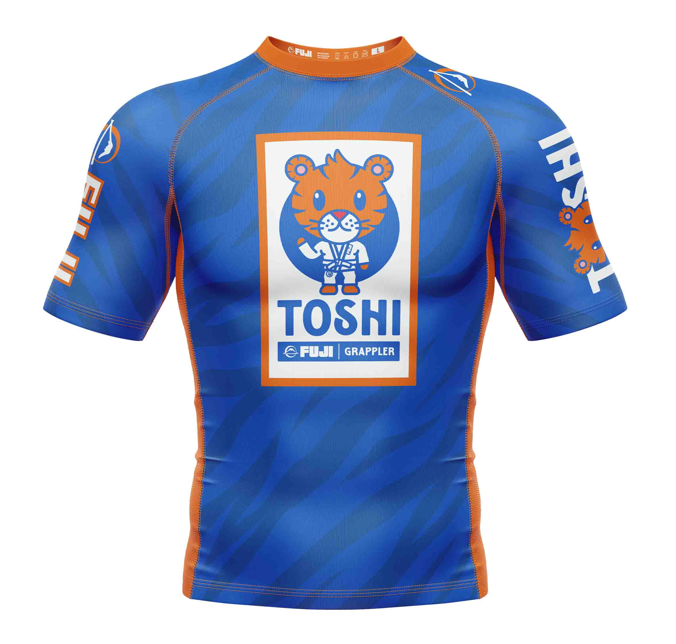 The Kids Toshi Rashguard Blue/Orange features blue and orange short sleeves, a cartoon tiger in a martial arts uniform, "TOSHI" text, and FUJI GRAPPLER branding on the front.
