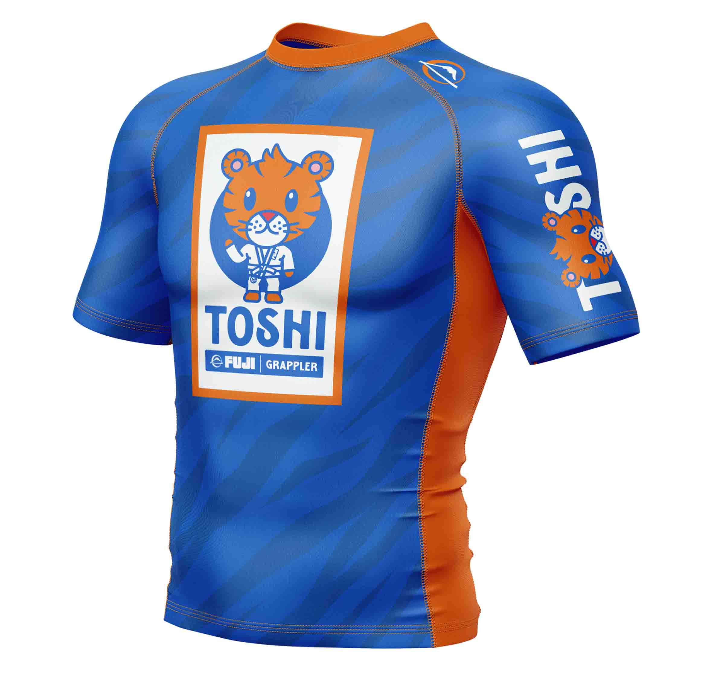 The Kids Toshi Rashguard Blue/Orange features a cartoon tiger in a martial arts gi with "TOSHI" text on the chest and a smaller version of the same design on the left sleeve.