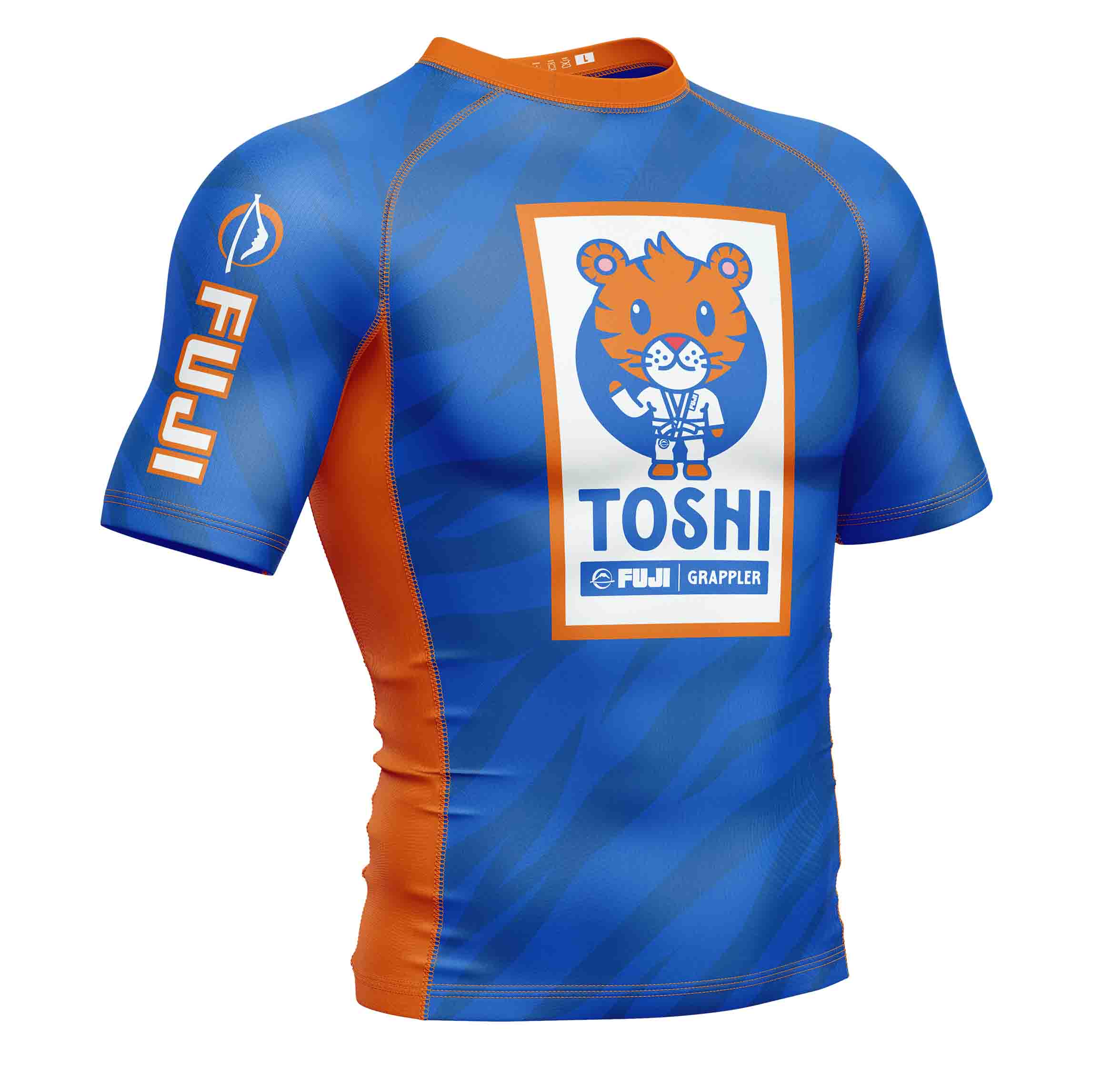 The Kids Toshi Rashguard Blue/Orange is a short-sleeve athletic shirt featuring a cartoon tiger in a martial arts gi with "TOSHI" and "FUJI GRAPPLER" on the front, plus "FUJI" on the sleeve.