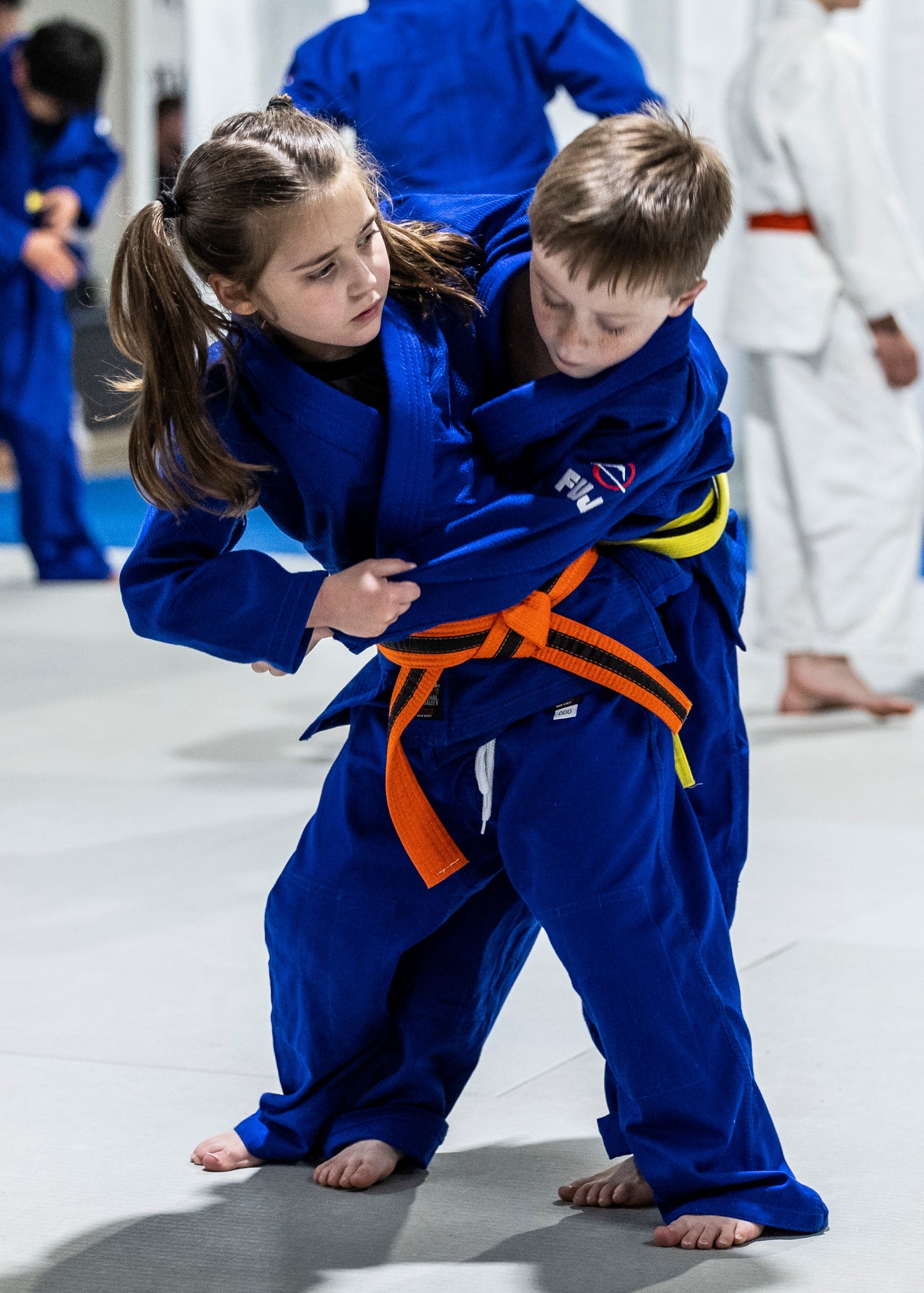 Two kids wearing blue judo gis